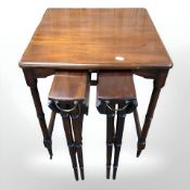 A reproduction occasional table with two stowaway tables beneath,