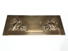 A continental embossed brass plaque depicting two griffins, width 37 cm.