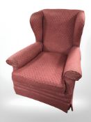 A wing backed armchair in red upholstery