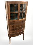 A reproduction mahogany bowfront cabinet, fitted drawers beneath, 52 cm x 40 cm x 128 cm.