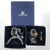 A Swarovski crystal figure of two owls perched on a branch and a further egg shaped box on stand,