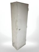 An enameled metal single door cabinet with shelved interior, 61 cm x 45 cm x 209 cm.