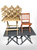 Three painted lattice folding tables, two expanding wooden bottle racks and a small folding chair.