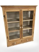 A 19th century glazed pine double door cabinet,