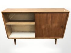 A 20th century teak sliding glass door low bookcase, designed by Herbet E.