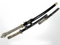 A reproduction Japanese katana, wakizashi and tanto, in scabbards,