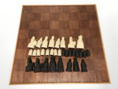 A teak chessboard, width 62 cm and a set of Medieval-style resin pieces, kings 9.5 cm high.