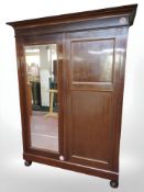 A 19th century continental mahogany double door wardrobe with mirror door