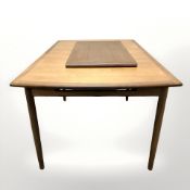 A 20th century teak extending dining table, with leaf, together with set of four dining chairs,