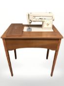 A Singer electric sewing machine in teak table.