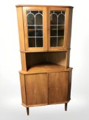 A 20th century Danish teak corner cabinet with leaded glass doors,