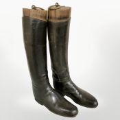 A pair of antique stitched leather riding boots, with wooden shoe trees, height 53 cm.