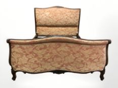 A French style carved walnut 4 ft 6 upholstered bedframe.