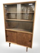 A 20th century teak sliding glass door bookcase,
