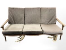 A 20th century teak framed three piece lounge suite comprising of three seater settee,