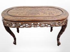 An oriental heavily carved hardwood oval occasional table,