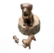 A black forest carved musical figure of a dog, height 17 cm and two further small carved dog.