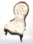 A Victorian carved walnut lady's chair in floral upholstery.