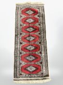 A Lahore Bokhara runner, 121 cm x 49 cm.