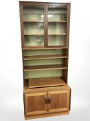 A G Plan teak bookcase, fitted cupboards beneath,