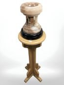 A polished onyx church font on oak pedestal, and a further church stool.