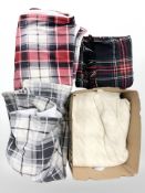 A woolen tartan blanket plus several others.