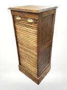 A 1920's oak tambour front office filing cabinet fitted with drawers,