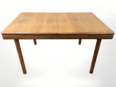 A 20th century White & Newton teak extending dining table with internal leaf,
