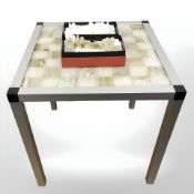 An onyx and aluminium chessboard table, width 42 cm, and a set of polished onyx chess pieces,