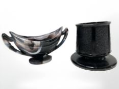 A Sowerby black glass match striker/holder and a purple slag glass twin-handled salt