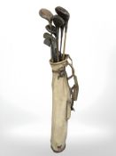 A vintage golf bag containing hickory shafted clubs, including Mashie, Niblick,