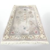 A Chinese rug on pale pink ground, 260 cm x 154 cm.