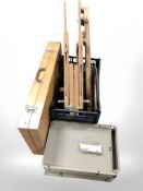 A folding table, three collapsible artists easels and three plastic artists trays.