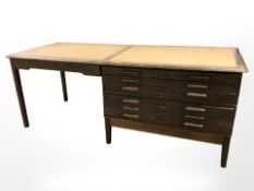 An early 20th century oak plan chest incorporating a writing table,
