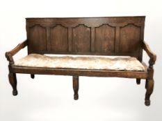 A George III panelled oak settle,