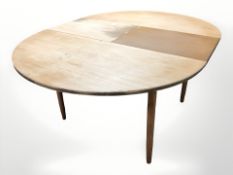 A 20th century teak oval extending dining table with two leaves,
