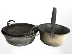 Two 19th century copper twin handled pans and a further brass jam pan, largest 46 cm diameter.