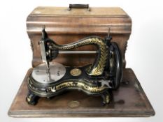 A Jones hand sewing machine, with associated walnut box.