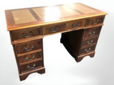 A reproduction twin pedestal nine drawer desk, 123 cm x 62 cm x 77 cm.
