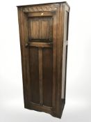 An early 20th century carved oak linen fold sentry door wardrobe, 76 cm x 45 cm x 186 cm.