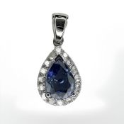A 14ct white gold sapphire and diamond pendant, featuring centre pear cut blue sapphire (0.