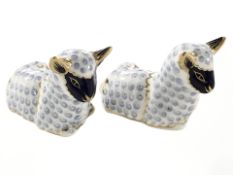 Two Royal Crown Derby lamb paperweights with gold stoppers.