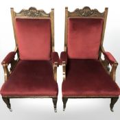 A pair of late Victorian carved oak library armchairs in red upholstery, width 72 cm.