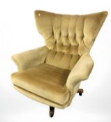 A 20th century G Plan model 6250 Blofeld swivel lounge armchair in buttoned mustard upholstery,