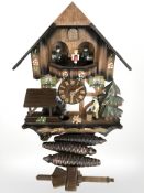 A reproduction cuckoo clock with pendulum and weights.