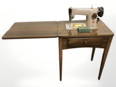 A Singer 201k electric sewing machine in table.