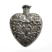 A silver heart shaped scent bottle.