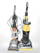A Dyson upright vacuum cleaner and a Vax carpet washer.