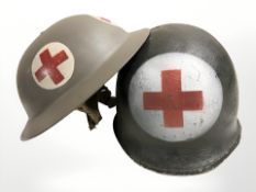 Two 20th century military medic helmets.