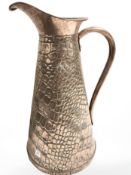 A 19th century embossed copper pitcher, height 29 cm.
